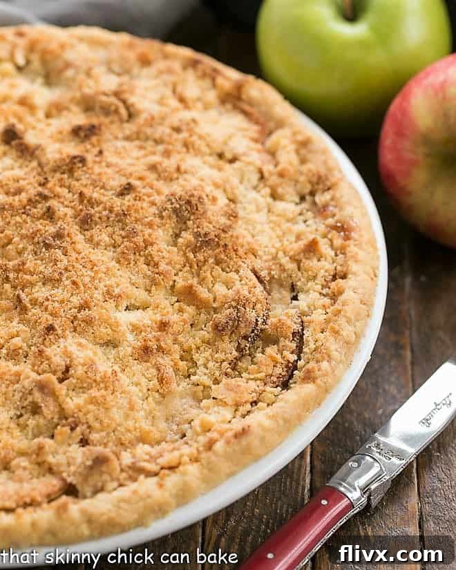 An inviting partial overhead view of a freshly baked Dutch Apple Pie, highlighting its golden-brown streusel topping and the warm, comforting appeal of a homemade dessert.