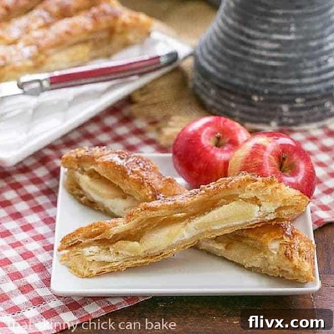 Two generous slices of a glistening Maple Glazed Apple Tart, perfectly arranged on a white square plate, inviting you to indulge in its seasonal flavors.