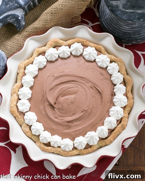 Classic French Silk Pie - A sublime, dreamy chocolate creation Classic French Silk Pie garnished with whipped cream in a red pie plate overhead view.