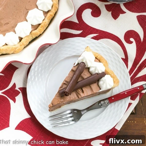 Classic French Silk Pie - A sublime, dreamy chocolate creation A slice of Classic French Silk Pie on a plate on a red and white napkin.