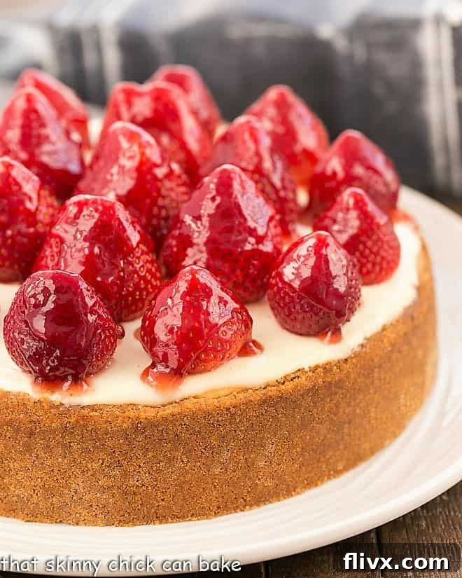 Strawberry Topped Cheesecake on white serving plate.