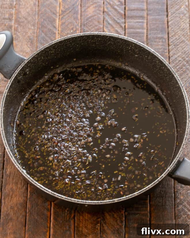 Step 3: Deglaze the pan with red wine and balsamic vinegar, then stir in fresh rosemary. Reduce the sauce by half until thickened.