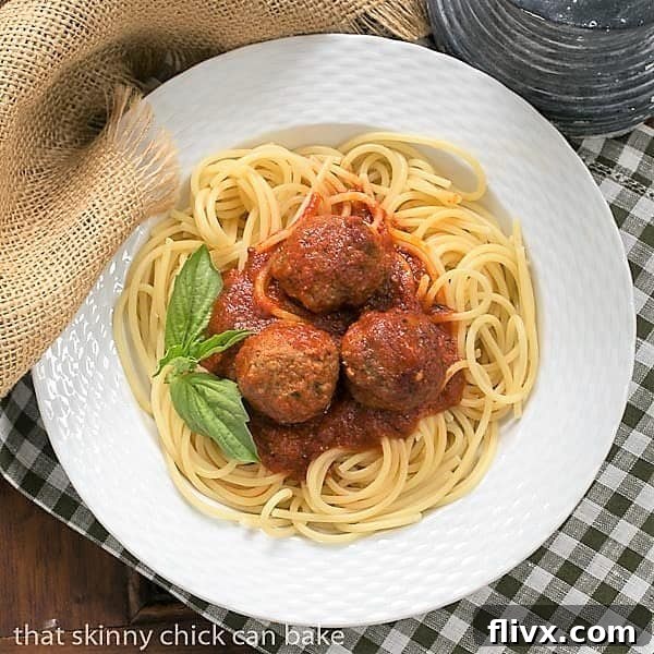 Overhead view of Classic Italian Meat Sauce over pasta and meatballs in a white bowl.