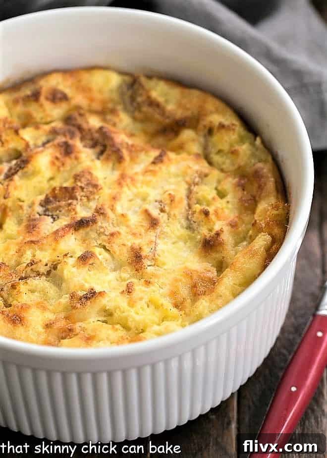 A golden-brown baked cheese soufflé, resembling an omelet, served in a ceramic casserole dish.