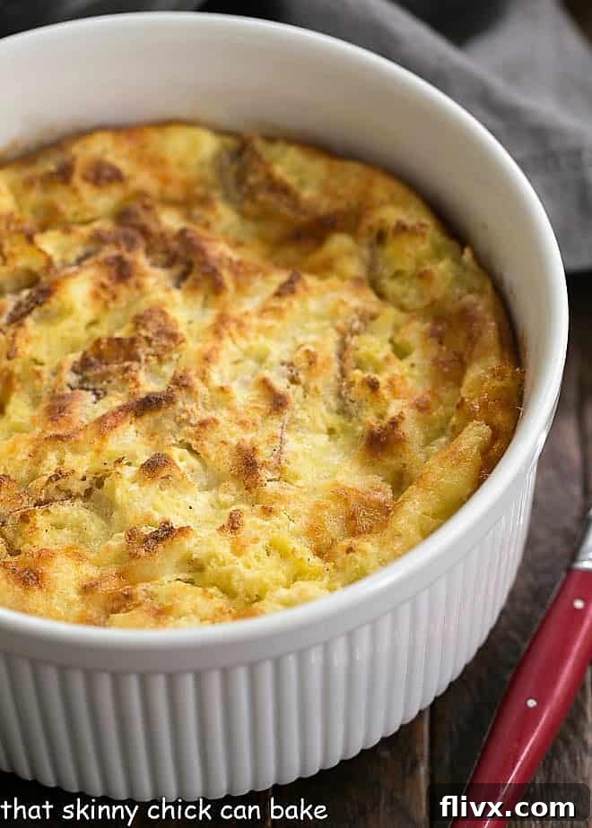 A beautifully baked cheese soufflé, resembling an omelet, in a casserole dish.