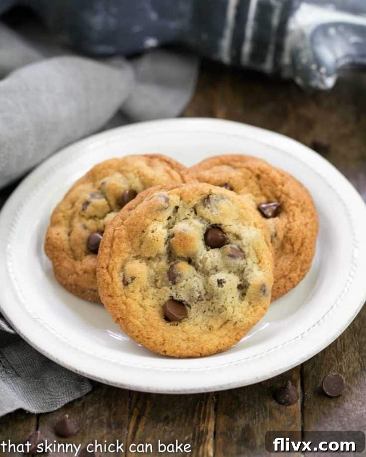 Thin and Chewy Chocolate Chip Cookies, golden brown with visible chocolate pools, ready to be enjoyed.