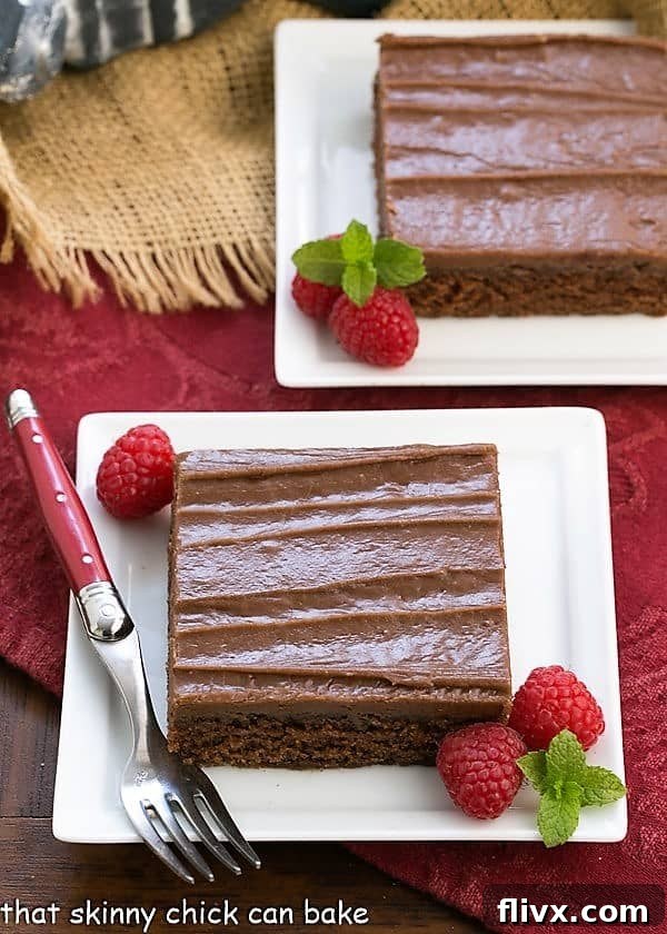 Chocolate Sheet Cake slices on a square white plates with raspberries