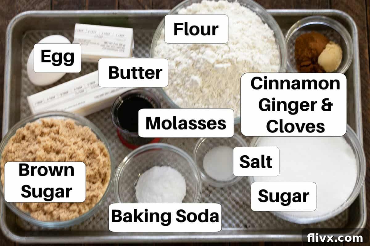 Labeled ingredients for gingersnaps, including butter, sugar, brown sugar, molasses, spices, flour, salt, and baking soda, neatly arranged on a metal baking sheet.