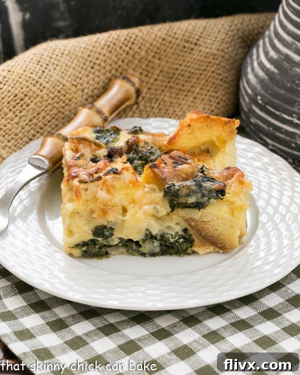 A square of spinach egg casserole on a small white plate on a green and white checked napkin.
