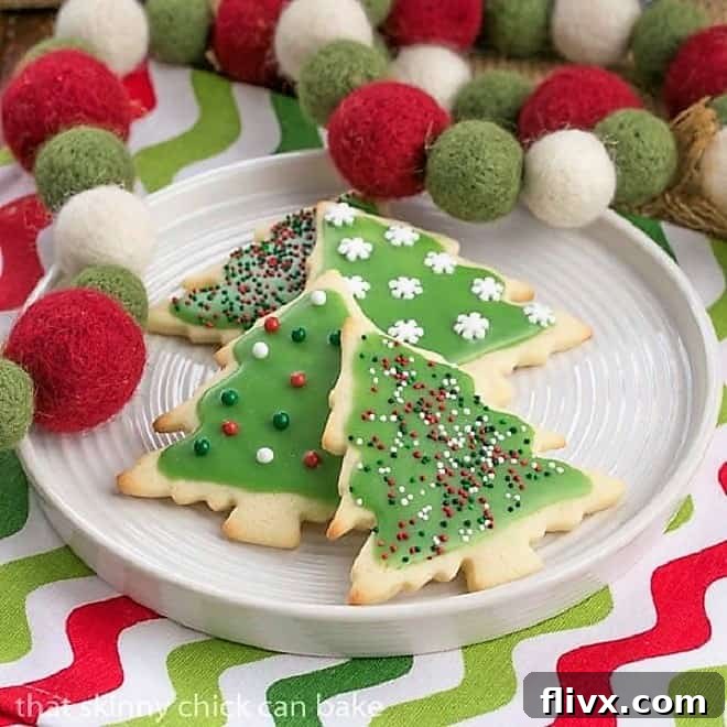 Best sugar cookies on a white plate with Christmas napkin and garland.