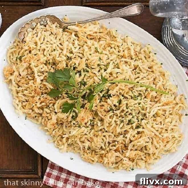 A generous serving of golden-brown Spaetzle, authentic German egg noodles, presented beautifully on a large serving platter, ready to be enjoyed as a delicious side dish.