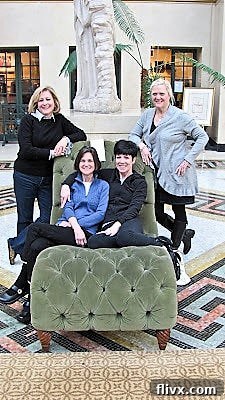 Four smiling girlfriends enjoying a weekend trip to French Lick, Indiana with neighbors, captured in a candid moment.