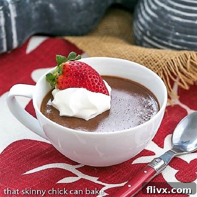 A delicate chocolate custard, perfectly set and presented in a classic white tea cup, highlighting its smooth texture and elegant simplicity.