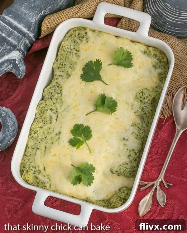 White casserole dish filled with baked Enchiladas Suizas, garnished with fresh toppings