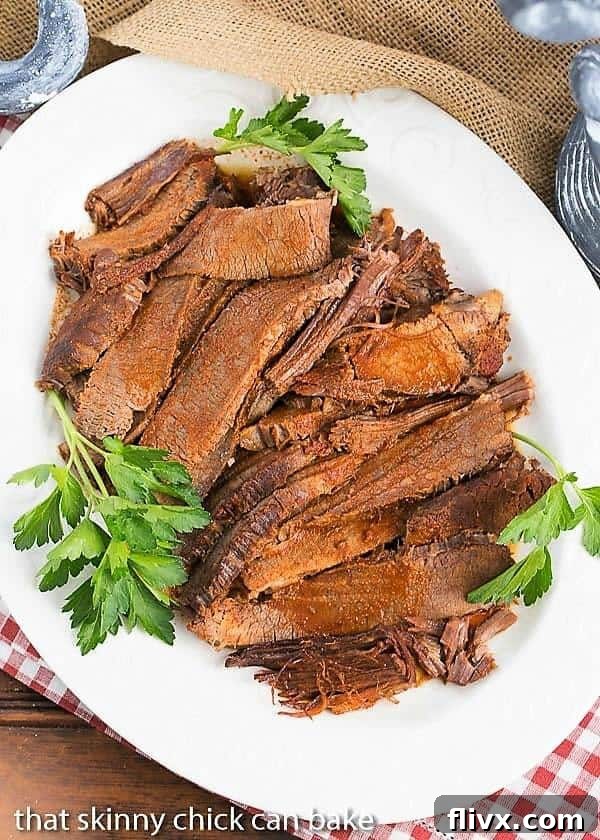 White serving platter filled with slices of Oven Braised Texas Brisket. 