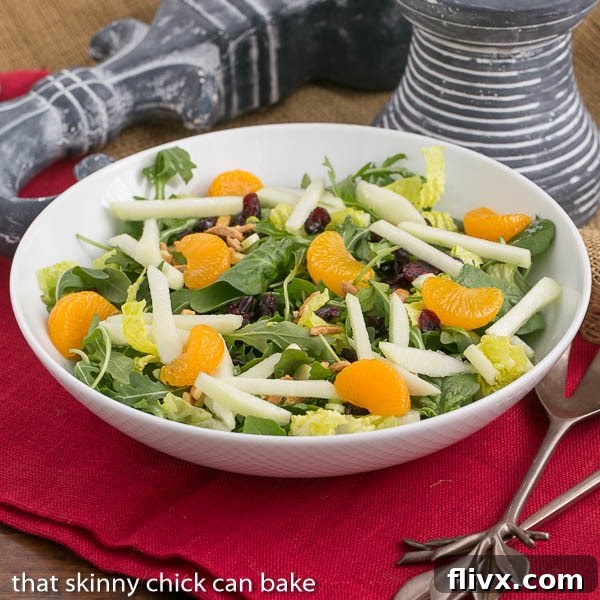 A vibrant Holiday Lettuce Salad in a beautiful white serving bowl, ready to be enjoyed.