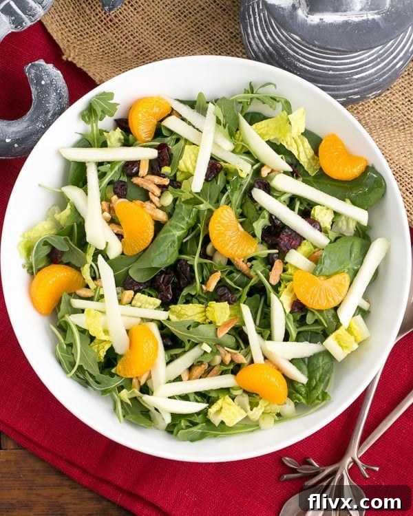 A close-up of the delicious Holiday Lettuce Salad, beautifully arranged in a serving bowl on a festive red napkin.