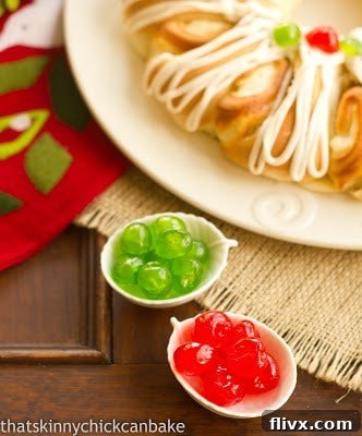 Overhead view of Cream Cheese Tea Ring dough before baking, alongside bowls of candied cherries and nuts