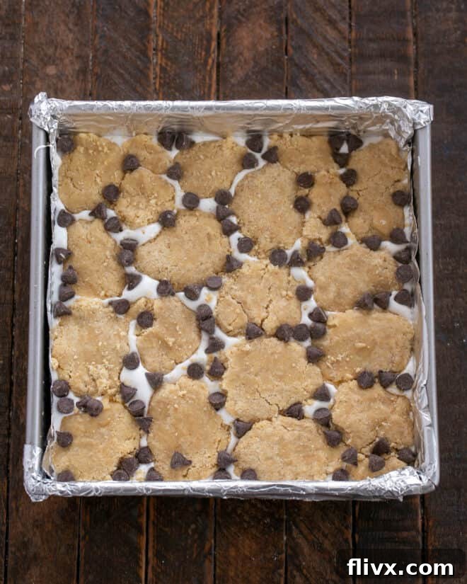 Scattering remaining cookie dough bits and chocolate chips over the marshmallow layer.