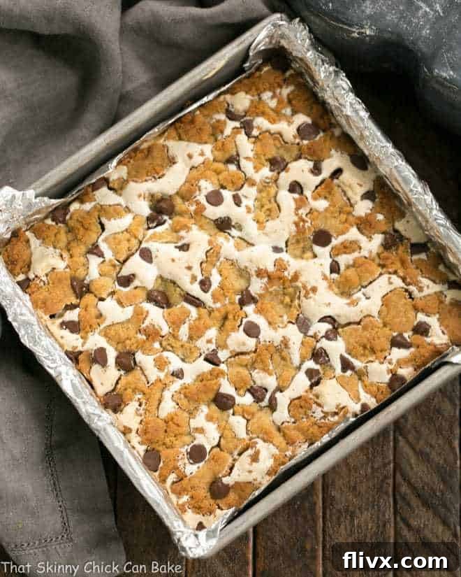 S'mores Cookie Bars baking in an oven, showing a golden brown top.