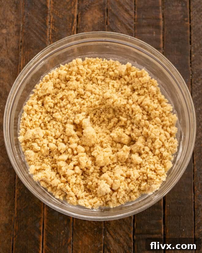 Stirring dry ingredients (flour, graham cracker crumbs, baking powder, salt) into the wet mixture.