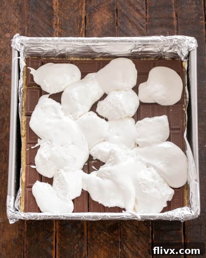 Dolloping marshmallow creme over the chocolate layer.