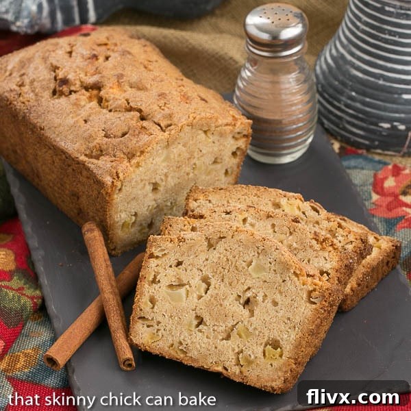 A whole loaf of Apple Bread and several slices arranged artfully on a slate tray, ready to be enjoyed.