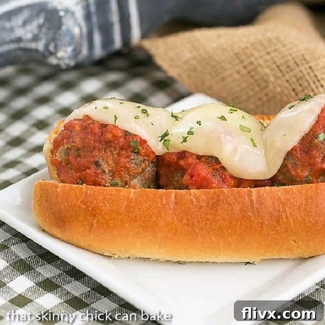 Meatball Sandwich on a white plate with gooey cheese topping.