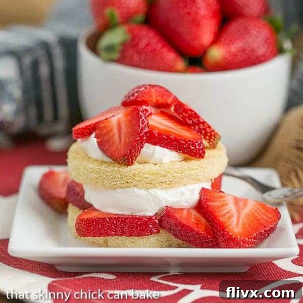 Delicious Strawberry Shortcakes with Olive Oil Cake rounds, topped with sweet whipped cream and juicy strawberry slices, presented beautifully on a plate.