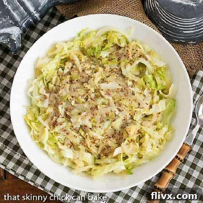 A plate of Sauteed Cabbage with Mustard and a serving spoon on the side of the dish.
