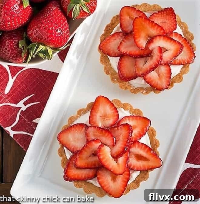 Exquisite Fresh Strawberry Tartlets with creamy filling and ripe strawberries, garnished with mint.