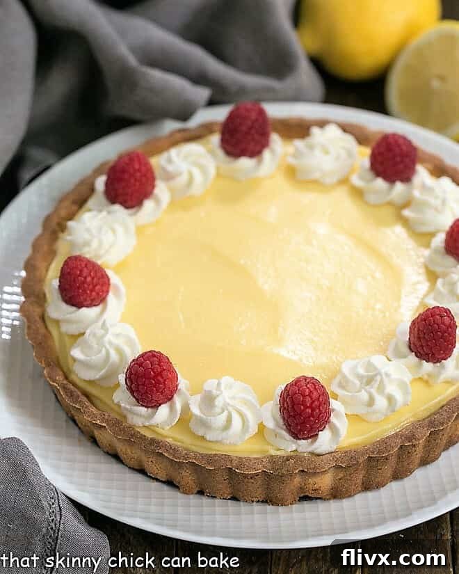 Close view of Creamy Lemon Tart on a white serving dish, perfectly smooth and inviting.