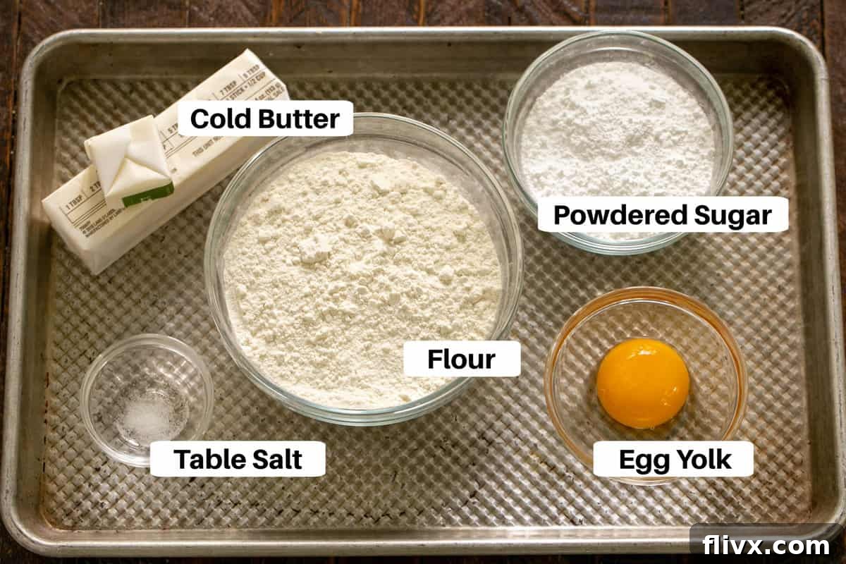 Lemon Tart Crust Ingredients displayed neatly on a sheet pan with labels, including flour, sugar, and butter.