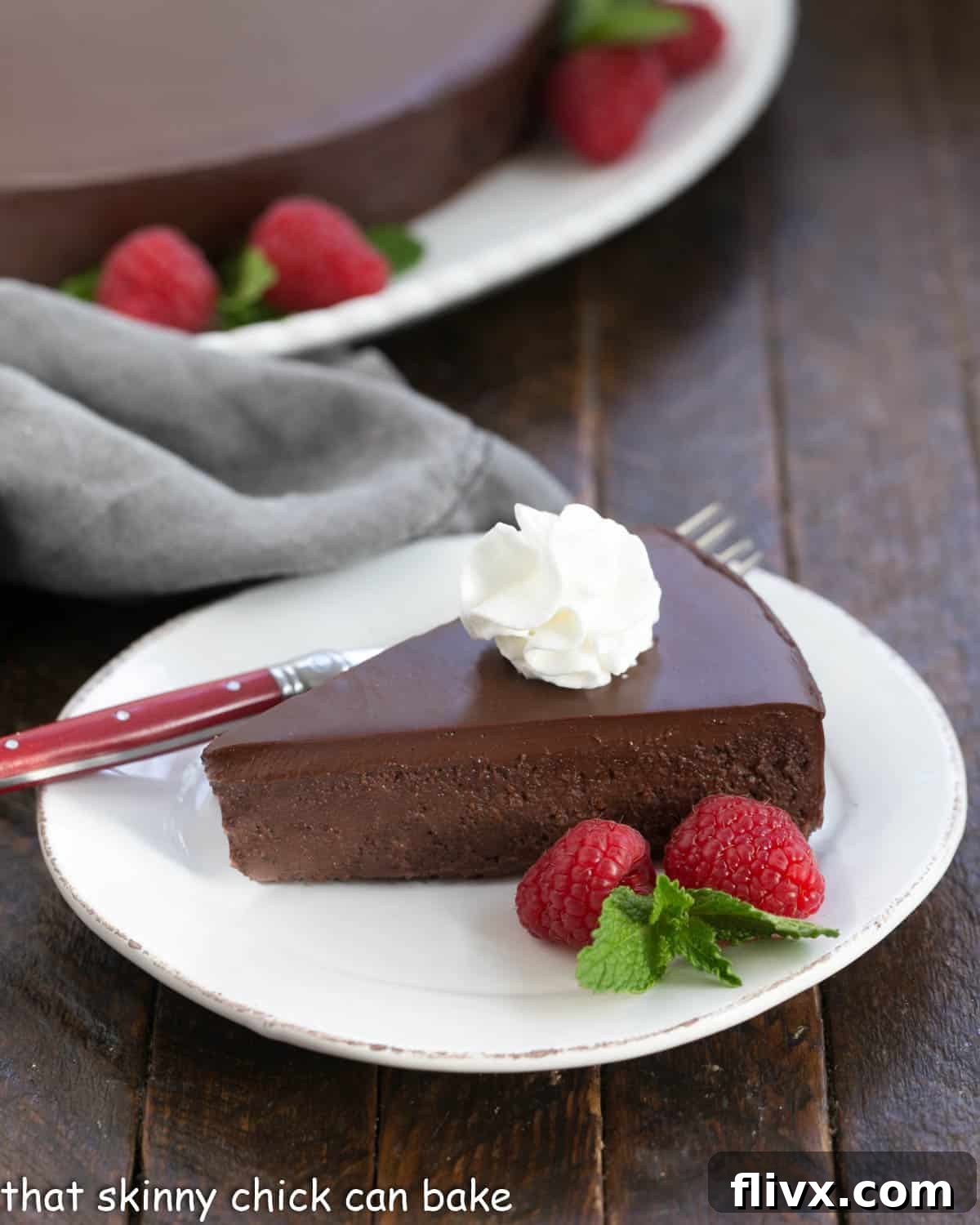 The Black Beast - dark, decadent and possibly the best chocolate cake recipe around! It's out of this world delicious! A perfectly sliced piece of La Bete Noire with a dollop of airy whipped cream on top, ready to be enjoyed.