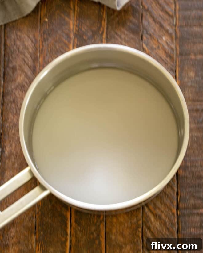 The Dark Nemesis 5 Step 2: Making the essential sugar syrup for La Bete Noire by simmering sugar and water in a saucepan.