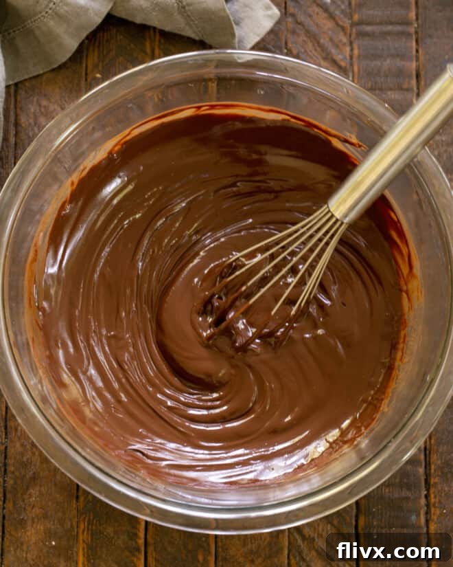 The Dark Nemesis 7 Step 4: Whisking the prepared sugar syrup into the melted chocolate and butter mixture for La Bete Noire.