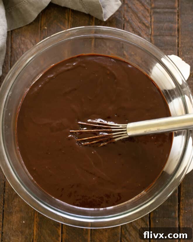 The Dark Nemesis 8 Step 5: Incorporating eggs into the chocolate mixture to create the smooth La Bete Noire batter.