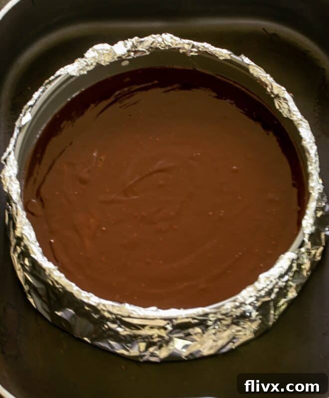 The Dark Nemesis 9 Step 6: Pouring the rich La Bete Noire batter into a foil-wrapped springform pan, prepared for a water bath.