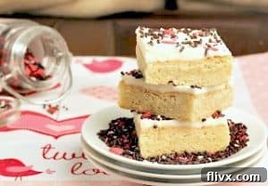 A stack of three white plates, each holding a beautifully frosted sugar cookie bar, ready to be enjoyed.