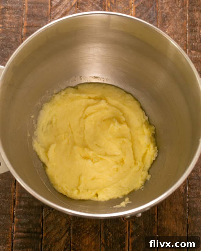 Step 1: Beating together butter and sugar, then mixing in egg, milk and extracts for sugar cookie bars.