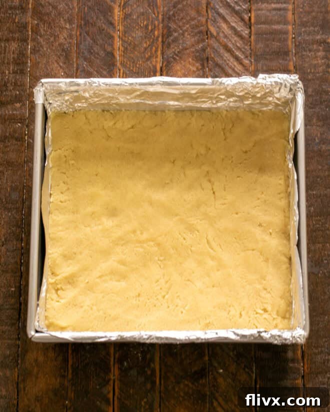 Step 3: Patting sugar cookie dough evenly into a prepared baking pan.