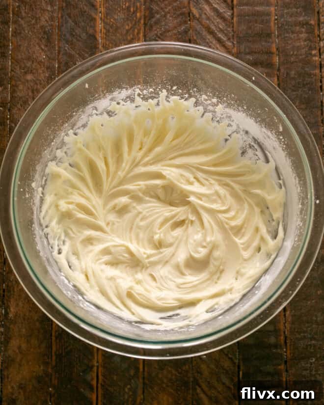 Step 5: Mixing frosting until fluffy, then applying it to cooled sugar cookie bars.
