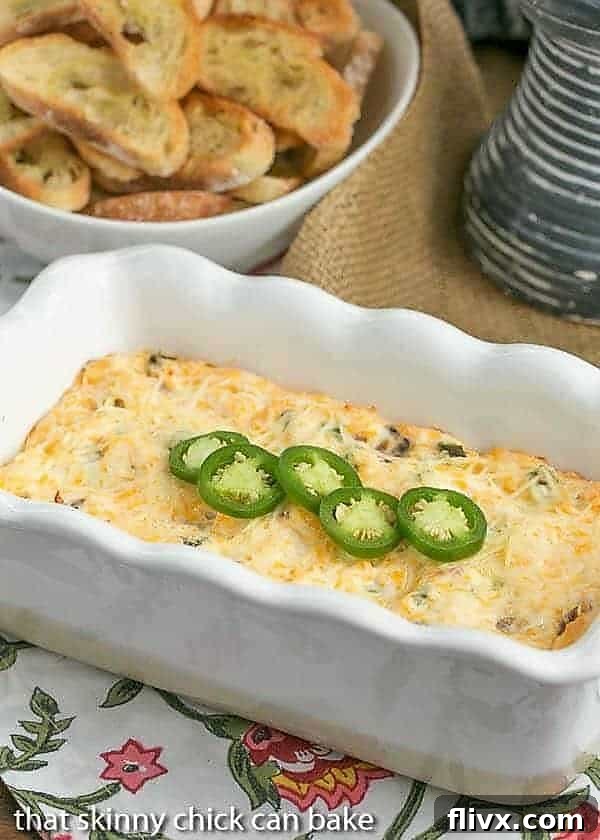 Jalapeno Popper Dip in a white ceramic loaf pan, garnished with bacon and fresh jalapenos