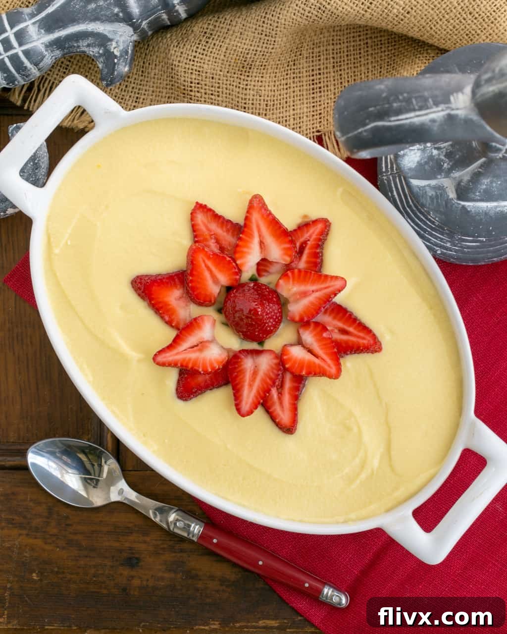 Berry Tiramisu with Grand Marnier - A strawberry twist on the Italian classic with mascarpone and Grand Marnier soaked ladyfingers! An oval casserole dish filled with Berry Tiramisu with Grand Marnier, garnished generously with fresh strawberry slices, ready to be served.