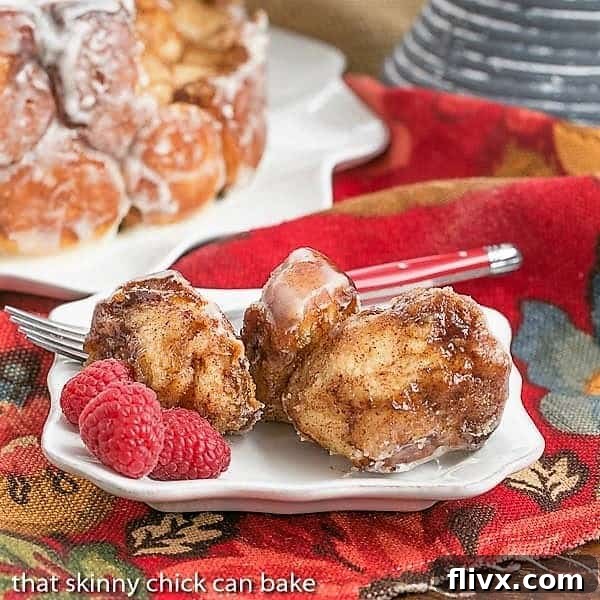 Cinnamon Bubble Roll pieces on a small white plate with fresh raspberries