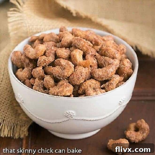A beautiful white serving bowl brimming with golden-brown Spicy Sugared Cashews, ready to be enjoyed.