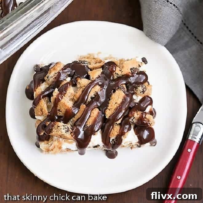 A beautiful, clean slice of Milk & Cookies Lasagna on a round white plate with a red handled fork, highlighting the distinct layers.