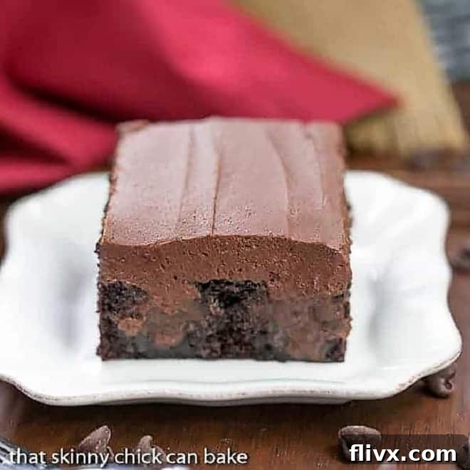 A slice of Triple Chocolate Poke Cake on a square white plate