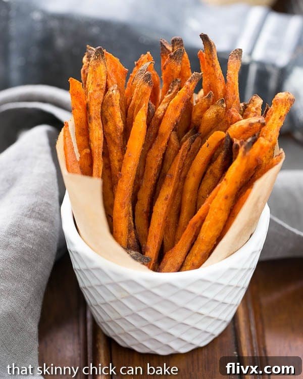 Spicy Sweet Potato Fries standing upright in a white ceramic bowl, showcasing their golden color and crispy texture.
