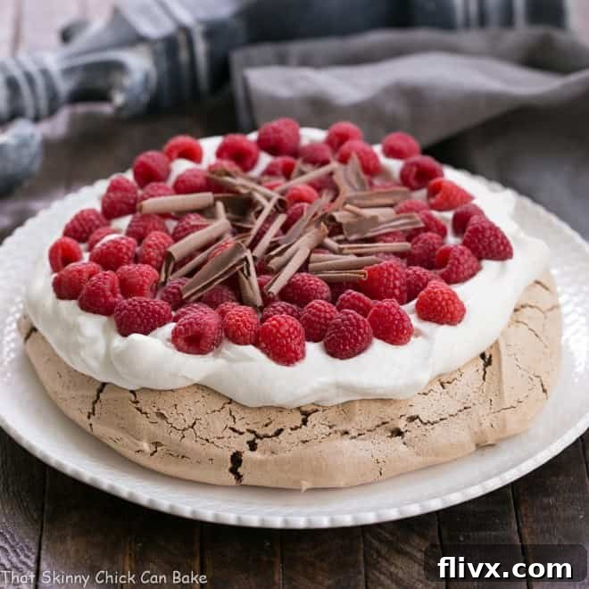 A delicate Chocolate Raspberry Pavlova, with crisp meringue, fresh berries, and cream.